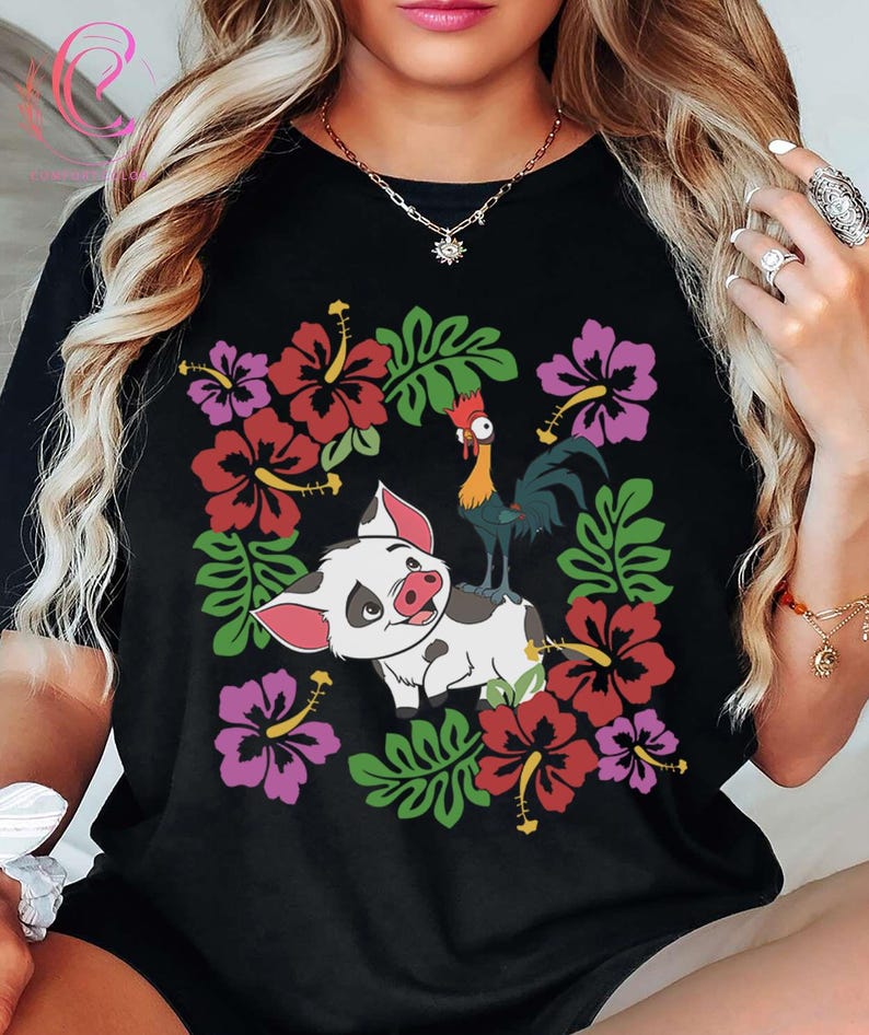 Może przedstawiać: Czarny t-shirt z kolorową grafiką świni, koguta, kwiat&oacute;w hibiskusa i zielonych liści. Świnia jest biała z czarnymi plamami i r&oacute;żowymi uszami. Kogut jest czerwony, ż&oacute;łty i niebieski. Kwiaty są czerwone i fioletowe.