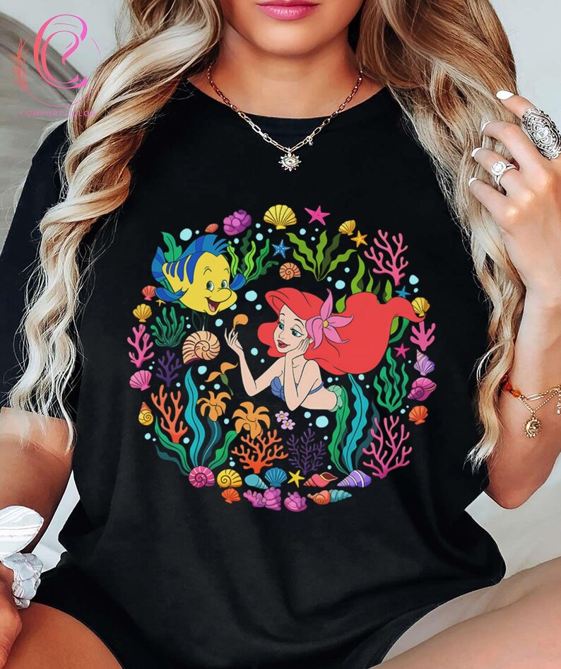 Pu&ograve; includere: Una tazza di ceramica bianca con manico nero e la scritta "But First, Coffee" in nero, in grassetto. La tazza &egrave; appoggiata su una superficie bianca.