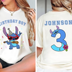 May include: Cream-colored t-shirt featuring a cartoon Stitch character wearing sunglasses and playing a ukulele, with the text "BIRTHDAY BOY" above. The back of the shirt displays the name "JOHNSON" and the number "3" with Stitch.