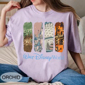 May include: Orchid-colored t-shirt featuring four vertical rectangular graphics with Disney World landmarks. The words "Walt Disney World" are printed in light blue. The word "ORCHID" is printed in a white oval at the bottom left.