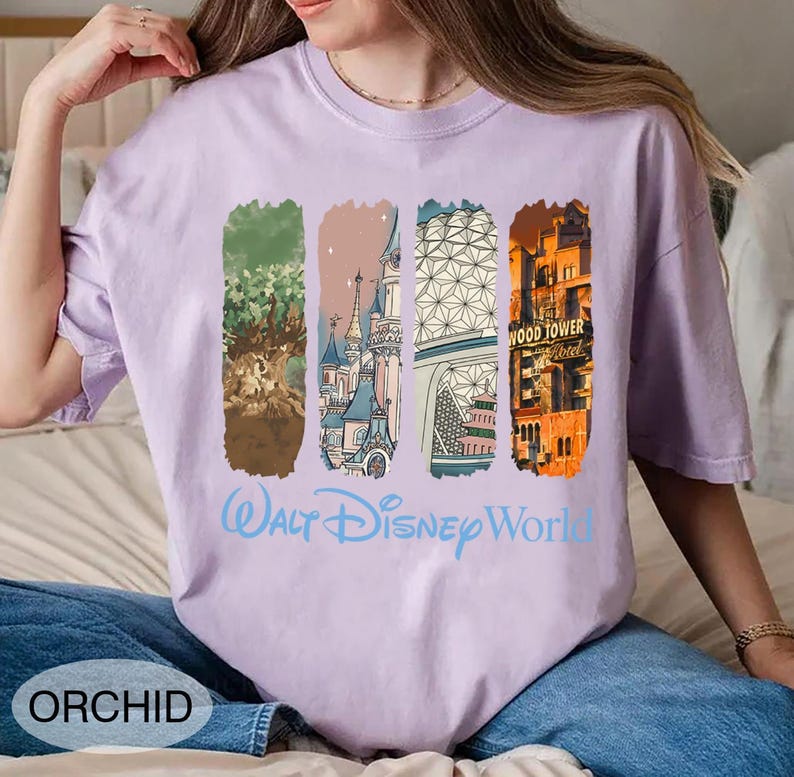 May include: Orchid-colored t-shirt featuring four vertical rectangular graphics with Disney World landmarks. The words "Walt Disney World" are printed in light blue. The word "ORCHID" is printed in a white oval at the bottom left.