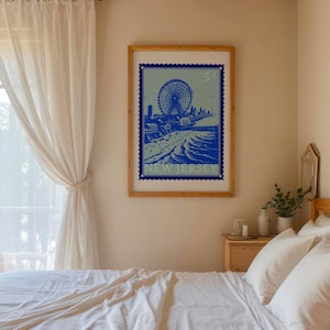 Puede incluir: Una ilustración vintage de estilo azul y blanco de una noria y una escena de playa en un póster con el texto "NEW JERSEY" y "5¢" en un marco de madera.