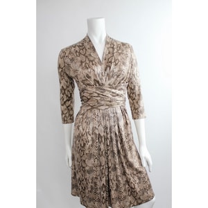 May include: A brown and beige snakeskin print wrap dress with a V-neckline and 3/4 sleeves.