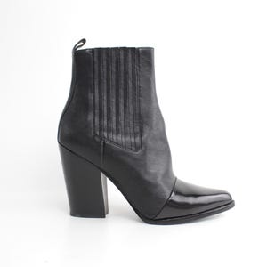 May include: Black leather ankle boots with a pointed toe and a block heel.