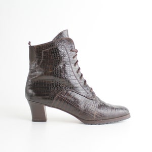 May include: Brown leather ankle boots with a lace-up front and a block heel.