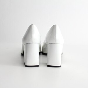 Puede incluir: Un par de zapatos de tac&oacute;n de charol blanco con tac&oacute;n de bloque.
