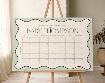 May include: A light green and cream-colored calendar with the text "Guess the arrival date of BABY THOMPSON" displayed on a wooden easel. The calendar grid shows the month of September and October.