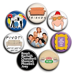 May include: A selection of circular pin badges with designs and text from the TV show "Friends." Designs include the Central Perk logo, a turkey with sunglasses, and the phrase "I'll be there for you."