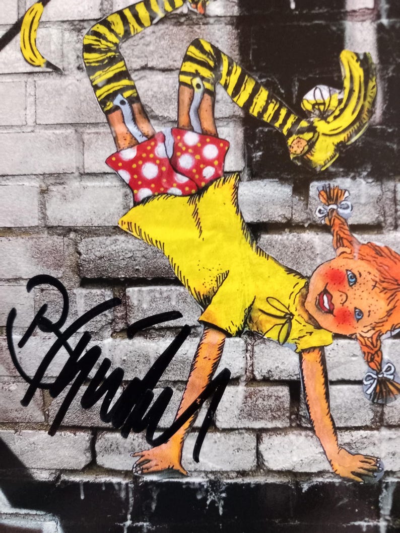 Puede incluir: Una ni&ntilde;a de dibujos animados amarilla, roja y negra haciendo una parada de manos en una pared de ladrillo. La ni&ntilde;a lleva pantalones amarillos con rayas negras, una camisa amarilla y una falda roja con lunares blancos. La ni&ntilde;a tiene el pelo rojo y una gran sonrisa. La imagen est&aacute; firmada "Anarchy" con un marcador negro.