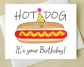 May include: A birthday card featuring a cartoon hot dog wearing a party hat. The hot dog has a smiling face, with the words "HOT DOG" above and "It's your Birthday!" below. The card is on a white envelope.