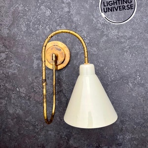 May include: A gold wall sconce with a white cone-shaped lampshade. The sconce has a curved arm and a round base.