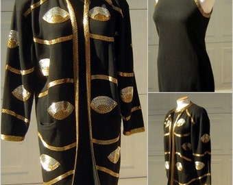 May include: A black knit dress and matching cardigan with gold and silver sequins in the shape of eyes. The cardigan has a long, loose fit and the dress has a sleeveless, fitted style.