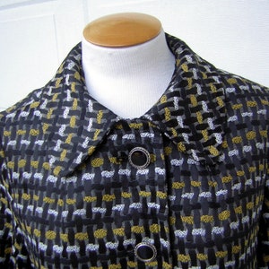 May include: A black, gold, and silver patterned jacket with a collar and button closure.