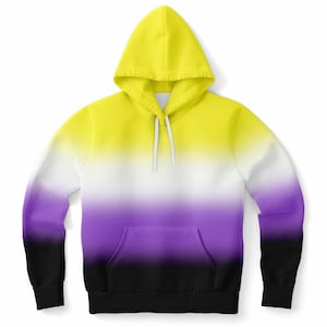 May include: A hooded sweatshirt with a non-binary pride flag design. The hoodie features a gradient of yellow, white, purple, and black. It has a front pocket and a drawstring hood. The sleeves and bottom hem are black.