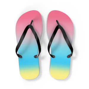 Puede incluir: Un par de chanclas negras con un diseño degradado en rosa, azul y amarillo.