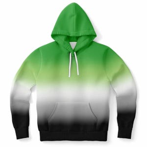 May include: A hooded sweatshirt with a gradient design. The top of the hoodie is bright green, transitioning to light green, white, gray, and finally black at the bottom. It features a front pocket and white drawstrings.