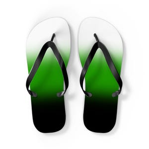 Puede incluir: Un par de chanclas negras con un diseño degradado de verde a negro.