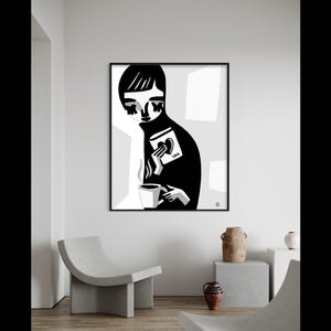 May include: Black and white art print of a person holding a mug and a book with the word "LOVE" on it. The person is wearing a black turtleneck. The art is framed in a black frame.