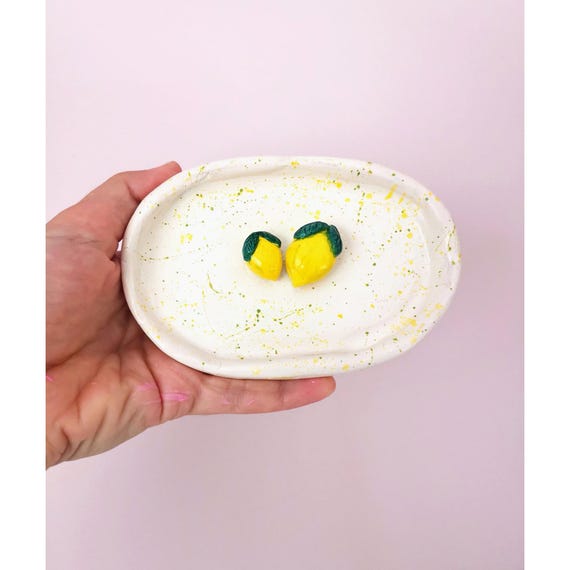 Hand-pinched ceramic dish shaped like a lemon slice — cheerful, tactile, and clearly made by human hands, not a mold.