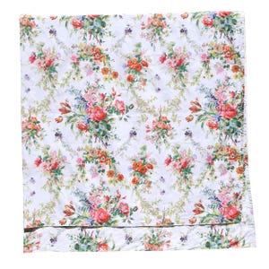May include: White fabric with a repeating floral pattern. The design features bouquets of pink, red, orange, and yellow flowers with green foliage. The flowers are arranged on a white background.