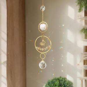 Peut inclure: Un attrape-soleil en cristal doré avec un petit charme de lapin suspendu à un cercle. L'attrape-soleil a trois perles de cristal et un grand prisme de cristal en bas.