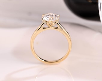 Può includere: Un anello di fidanzamento in oro con un diamante rotondo e chiaro incastonato a griffe. L'anello ha una fascia semplice.