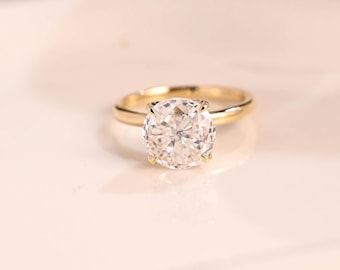 May include: A gold engagement ring with a large, round, clear diamond.