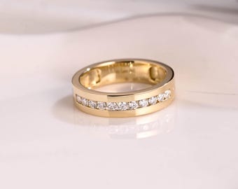 May include: A gold band ring with a row of small diamonds set in the center.