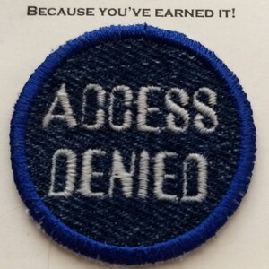 May include: A blue and white embroidered patch with the text "Access Denied" in white lettering on a blue background.