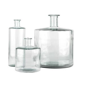 May include: Three clear glass vases of different sizes and shapes. The largest vase is a wide, squat cylinder. The medium vase is a shorter, wider cylinder. The smallest vase is a tall, thin cylinder.
