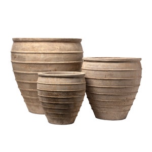 May include: Three terracotta pots with a ribbed design. The pots are different sizes and are arranged in a row from largest to smallest.