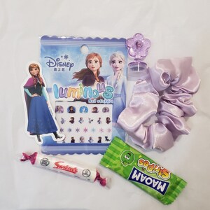 May include: A Frozen themed party favor bag with a purple hair scrunchie, a pack of nail stickers, a small bottle of nail polish, a pack of candy, and a small plastic flower charm.