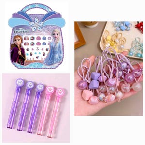 May include: A set of Frozen II themed children's accessories including a purple and pink bubble wand, a set of nail stickers in a purple and blue carrying case, and a set of purple and pink hair ties with various charms.