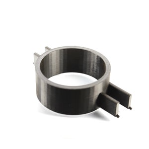 K&ouml;nnte beinhalten: Ein schwarzer und grauer 3D-gedruckter Ring mit einer strukturierten Oberfl&auml;che. Der Ring hat ein kleines, flaches, rechteckiges St&uuml;ck, das seitlich herausragt.