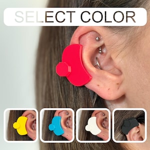 May include: A close-up of an ear with a red ear support device. The image also shows the same device in yellow, blue, white, and black. The text "SELECT COLOR" is at the top of the image.