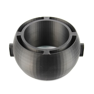 May include: A black 3D printed ring with a hollow centre and a textured surface.