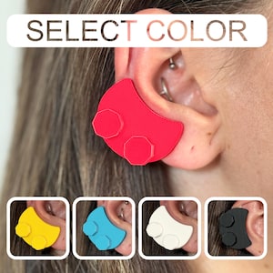May include: A red ear accessory with two attached hexagonal shapes, worn on an ear. The image includes the text "SELECT COLOR" and displays the accessory in yellow, blue, white, and black.