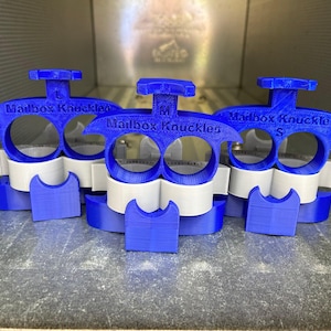 Puede incluir: Tres nudillos de buzón de plástico azul, etiquetados como "Mailbox Knuckles" con los tamaños "L", "M" y "S".