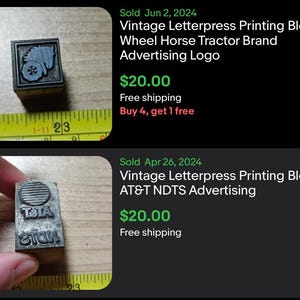 May include: Two vintage letterpress printing blocks. One block features a Wheel Horse Tractor Brand advertising logo. The other block features an AT&T NDTS advertising logo. Both blocks are made of metal and are rectangular.