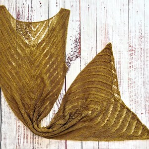 Pode incluir: Um xale de malha e um top sem mangas a condizer, na cor mostarda. O xale &eacute; triangular, com um padr&atilde;o de riscas texturizadas. O top tem decote em V e um design em ziguezague. Ambos os artigos s&atilde;o feitos de um material macio e de tecido aberto.
