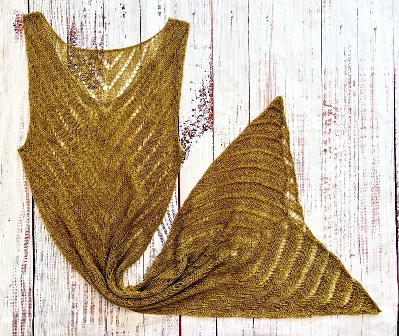 Pode incluir: Um xale de malha e um top sem mangas a condizer, na cor mostarda. O xale &eacute; triangular, com um padr&atilde;o de riscas texturizadas. O top tem decote em V e um design em ziguezague. Ambos os artigos s&atilde;o feitos de um material macio e de tecido aberto.