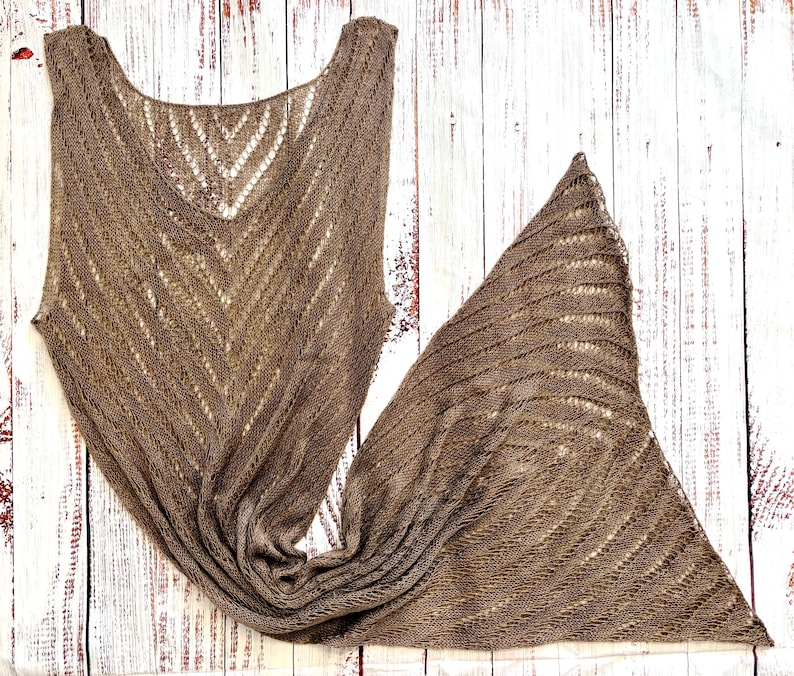 Pode incluir: Um xale e um top a condizer em malha castanha de tecido aberto. O xale &eacute; triangular e o top tem decote em V e design sem mangas. Ambas as pe&ccedil;as apresentam um padr&atilde;o de espinha de peixe e s&atilde;o exibidas numa superf&iacute;cie de madeira branca.