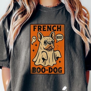 May include: Dark gray t-shirt featuring a Halloween-themed graphic. The design includes a French Bulldog dressed as a ghost with the text "FRENCH BOO-DOG" and a speech bubble that says "BOO!".