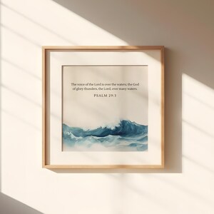 May include: A framed print with a watercolor painting of ocean waves. The print includes the text "The voice of the Lord is over the waters; the God of glory thunders, the Lord over many waters. Psalm 29:3"