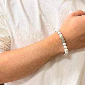 May include: White beaded bracelet with a silver charm that says "Limitless".