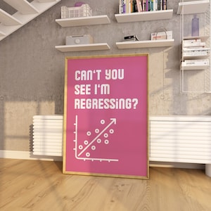 May include: A pink poster with a gold frame featuring a white line graph with the text "Can't you see I'm regressing?"