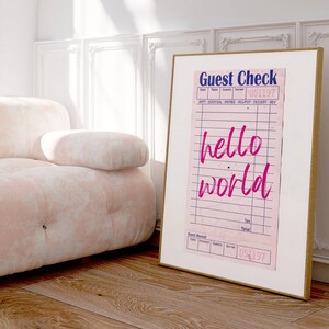 May include: A framed print of a pink guest check with the words "hello world" written in pink cursive. The date on the check is 051197.