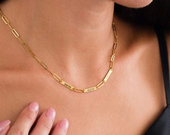 May include: Gold chain necklace with four rectangular name tags. The name tags read "LAVIA", "ELDON", "DAVIN", and "LILA".