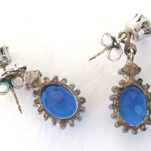 Back of vintage Avon blue crystal glass set includes a necklace whose pendant may be used as a brooch, an adjusting ring, and a pair of dangle post earrings.
