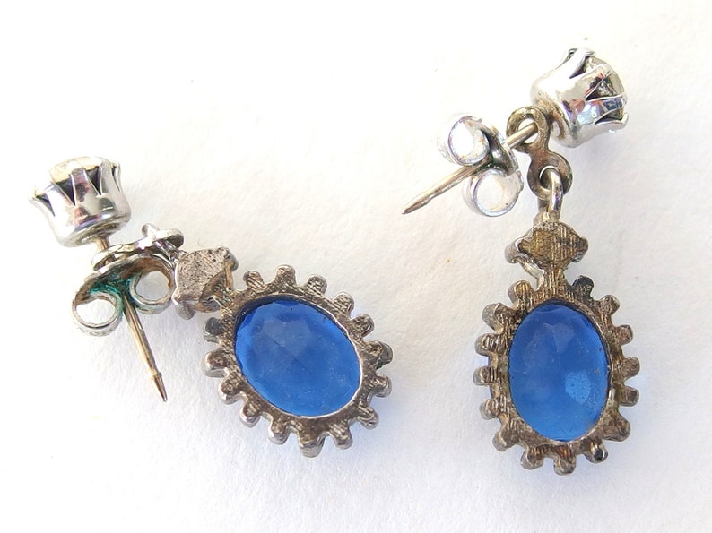 Back of vintage Avon blue crystal glass set includes a necklace whose pendant may be used as a brooch, an adjusting ring, and a pair of dangle post earrings.